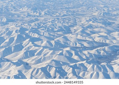 Aerial view of snow-capped mountains. Winter snowy mountain landscape. Air travel to the far North of Russia. Kolyma Mountains, Magadan Region, Siberia, Russian Far East. Great for the background. - Powered by Shutterstock