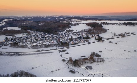 An Aerial View Of A Snowy Mountain Village At Sunset