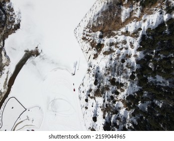 An Aerial View Of Snowy Road Between Range Of Mountains Against A Light Blue Sky Rogers Pass, Canada