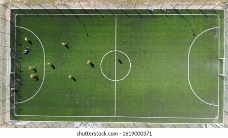 Aerial view of a soccer game being played at nighttime with floodlights lighting the field. - Powered by Shutterstock