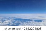 Aerial view of soft cloud layers seen from high flying commercial airplane window.