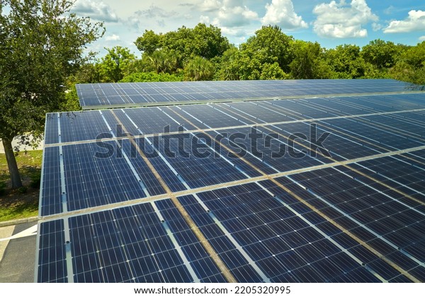 Aerial view of solar panels installed as\
shade roof over parking lot for parked cars for effective\
generation of clean electricity. Photovoltaic technology integrated\
in urban infrastructure