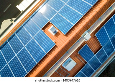 Aerial view of solar photo voltaic panels system on apartment building roof. Renewable ecological green energy production concept. - Shutterstock ID 1403947616