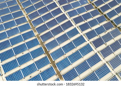 Aerial view of solar power plant with blue photovoltaic panels mounted of industrial building roof. - Shutterstock ID 1832695132