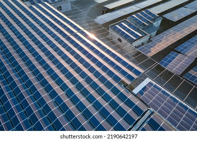 Aerial view of solar power plant with blue photovoltaic panels mounted on industrial building roof for producing green ecological electricity. Production of sustainable energy concept - Shutterstock ID 2190642197