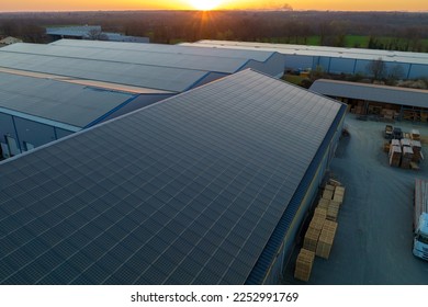 Aerial view of solar power plant with blue photovoltaic panels mounted on industrial building roof for producing green ecological electricity. Production of sustainable energy concept - Shutterstock ID 2252991769