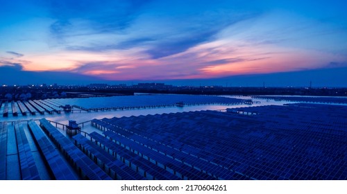 Aerial View Of Solar Power Station At Beautiful Sunset. Solar Photovoltaic Power Station On Water. Green Energy Concept.