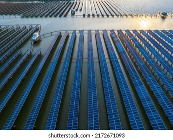 Aerial View Of Solar Power Station At Beautiful Sunset. Solar Photovoltaic Power Station On Water. Green Energy Concept.