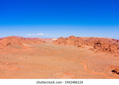 Aerial View Of The Southwest Nevada Desert With Sandstone Mountains And A Blue Sky.