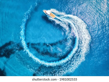 Aerial view of the speed boat in clear blue water at sunny day in summer. Top view from drone of fast floating yacht in mediterranean sea. Travel in Oludeniz, Turkey. Tropical landscape with motorboat