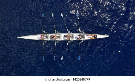 Aerial View Of Sport Canoe Operated By Team Of Young Atheletes In Deep Blue Open Ocean Sea