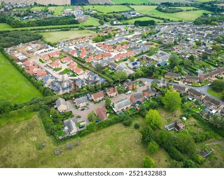Aerial view of a sprawling housing development of private bungalows seen in the village of Wimblington, Cambridgeshire, UK. A road bypass can be seen in the distance.