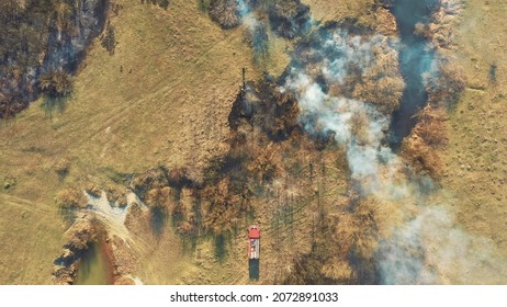 Aerial View. Spring Dry Grass Burns During Drought Hot Weather. Bush Fire And Smoke. Fire Engine, Fire Truck On Firefighting Operation. Wild Open Fire Destroys Grass. Ecological Problem Air Pollution.