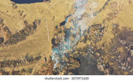 Aerial View. Spring Dry Grass Burns During Drought Hot Weather. Bush Fire And Smoke. Fire Engine, Fire Truck On Firefighting Operation. Wild Open Fire Destroys Grass. Ecological Problem Air Pollution.