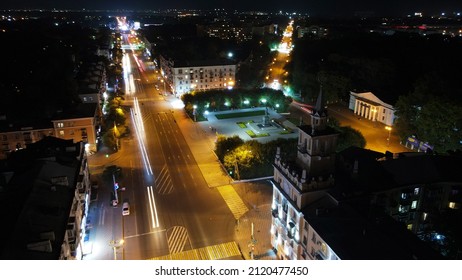 Aerial view of the square on main street in night with excerpt, roads, city, top	
				
