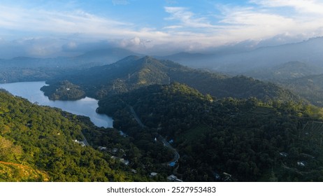 Aerial view of Sri Lankan hills at dawn. Explore the stunning green hills of Sri Lanka at dawn, with a tranquil lake nestled among the trees and mist rolling over the mountains. - Powered by Shutterstock