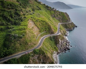 Aerial View Of The SS113, A Winding Road On The Edge Of A Rocky Cliff Above The Deep Blue Tyrrhenian Sea Between Capo Skino And Capo Calava On The Northern Coast Of Sicily.