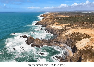 Aerial view of the steep cliffs and ocean waves crashing into the shore. Fishermen's Trail in Alentejo, Portugal - Powered by Shutterstock