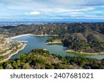 Aerial view of Stevens Creek Reservoir in Santa Clara County, California during winter. Background Silicon Valley.