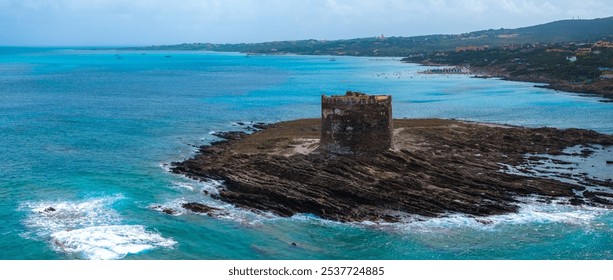 Aerial view of a stone tower on a rocky outcrop in Sardinia, surrounded by turquoise sea. Sandy beach with people and lush greenery in the background. - Powered by Shutterstock