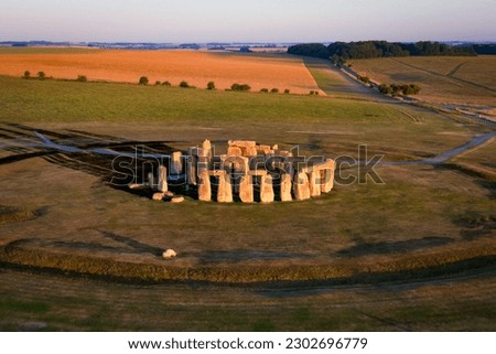Aerial view to Stonehenge prehistoric megalith monument arranged in circle at sunrise.