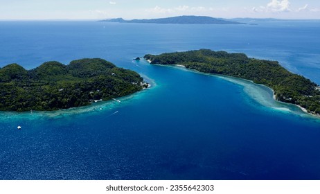 Aerial view of the strait between two tropical islands in the Pacific Ocean. Blue sea and green islands.