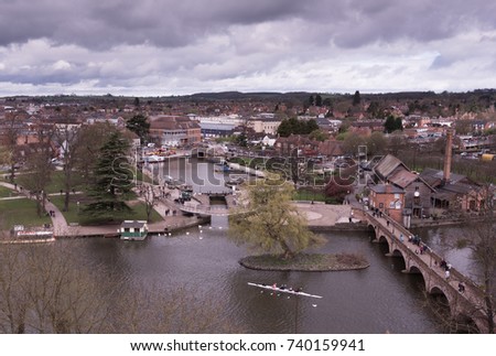 aerial view of Stratford upon Avon UK in Shakespeare's England with swans and canal basin and lock in the foreground and Welcombe Hills and stormy skies n the background