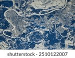 Aerial view of a stunning oxbow lake, a geological wonder formed by a meandering river. The electric blue water contrasts beautifully with the surrounding. Elements of this image furnished by NASA