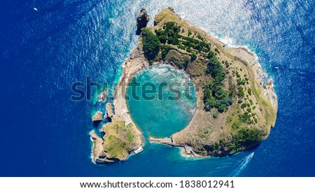 Aerial view of submerged volcano crater in the deep blue and azure Atlantic Ocean called Ilheu de Vila Franco do Campo which is part of the Azores on Sao Miguel Island, Portugal.