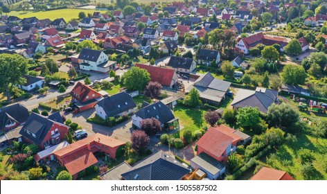 Aerial view of a suburb with detached houses, garden areas, lawns and a close neighbourhood