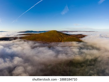 Aerial View Of The Sugar Loaf Mountain In The Brecon Beacons Rising Above A Sea Of Cloud And Fog.