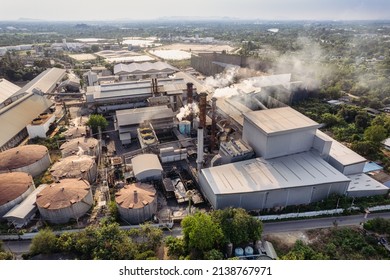 Aerial View Of Sugar Processing Plant With Pollution Smoke From Chimney And Tank Warehouse In Agricultural Industrial Factory. Global Warming And Climate Change Problem