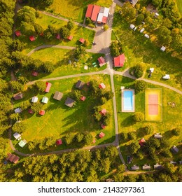 Aerial view of summer camp. Cabins, caravans, swimming pool, tennis court and beach volleyball court from top down view. Summer holidays camping background concept. - Powered by Shutterstock