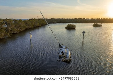 Aerial view of sunken sailboat on shallow bay waters after hurricane in Manasota, Florida - Powered by Shutterstock