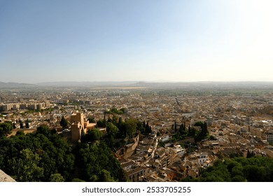 Aerial view of a sunlit Mediterranean city with tightly packed historic buildings, whitewashed facades, and lush greenery, set against rolling hills. - Powered by Shutterstock