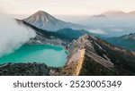 Aerial view of sunrise at a volcanic caldera, Ijen volcano crater in East Jawa, Indonesia, volcanic lake with sulphur gases at dawn, tourism in Ijen volcano national park in Jawa.