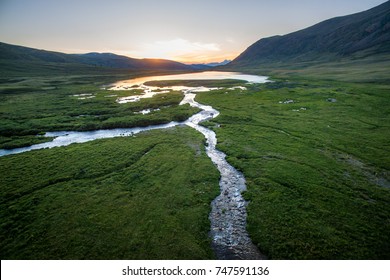 Aerial View Of Sunset At The Beautiful Russian River Among The Green Mountains In Siberia