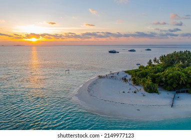 Aerial view of the sunset over a sandy island with palm trees and travelers in the Indian Ocean - Shutterstock ID 2149977123