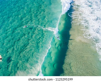 An aerial view of a surfer riding a wave at the beach on the Gold Coast in Queensland Australia