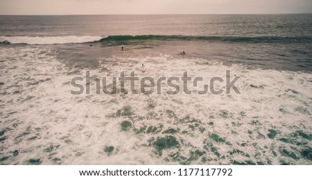 Aerial view surfers and wave in tropical ocean. Top view