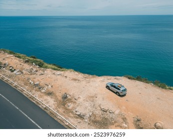 Aerial view of SUV car arriving on beach with beautiful sea view. Royalty high-quality free stock image top view adventure road trip between mountain rock and ocean. Driving road along, traveling - Powered by Shutterstock