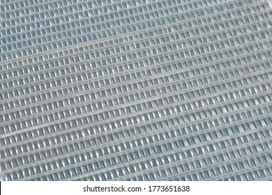 An aerial view taken from a helicopter of a huge greenhouse used for growing plants and vegetables. Very large industrial polythene tunnels making an abstract striped pattern.