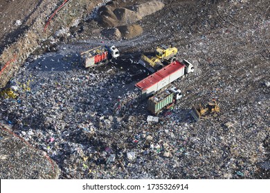 Aerial view taken from a helicopter of a landfill site in the UK. It contains trucks and machinery depositing rubbish as well as hundreds of gulls feeding on the garbage.