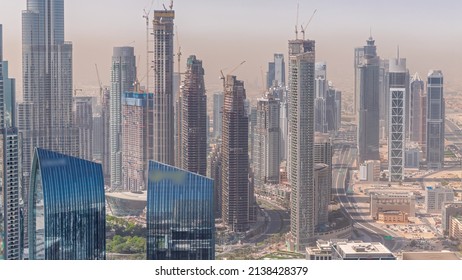 Aerial view of tallest towers in Dubai Downtown skyline and highway timelapse. Financial district and business area in smart urban city. Skyscraper and high-rise buildings under construction