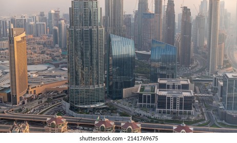 Aerial view of tallest towers in Dubai Downtown skyline and highway timelapse. Financial district and business area in smart urban city. Skyscraper and high-rise buildings during sunset