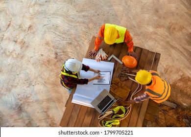 Aerial View Of Team Of Engineer And Architects Meeting And Planning Measuring Layout Of Building Blueprints At Construction Site.