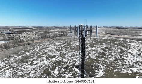 Aerial view of a telecom self support cell tower antennas in rural area in spring. Drone closeup view of a guyed cell tower top, scenic view late spring, snow. - Powered by Shutterstock