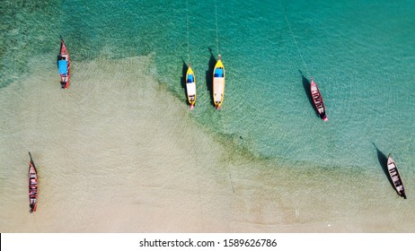 Aerial view of Thai traditional wooden longtail boat on Phuket beach, Thailand, Top view from flying drone.