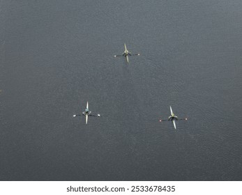 An aerial view of three rowers in single sculls on Burnaby Lake, BC, Canada - Powered by Shutterstock