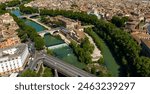 Aerial view of Tiber Island, the only river island Rome, Italy. In the background is the historic center of the Italian capital. It is connected to the city via two bridges.